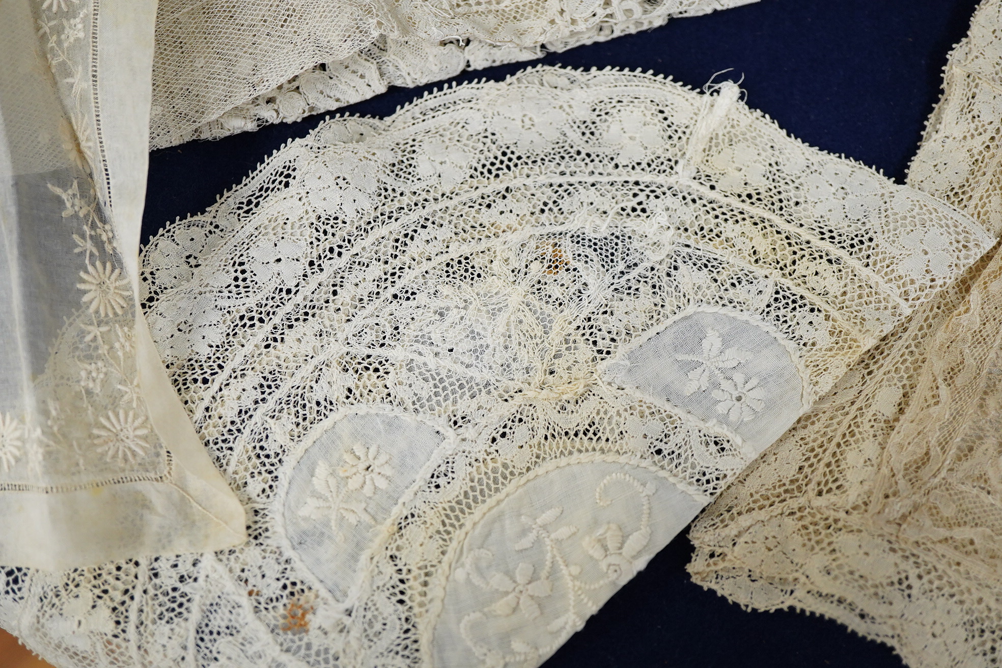 A late 19th / early 20th century circular Normandy lace table cover, with five similar smaller lace mats: all patch worked together from hand bobbin and hand needle laces, possibly part of a wedding trousseau. larger clo